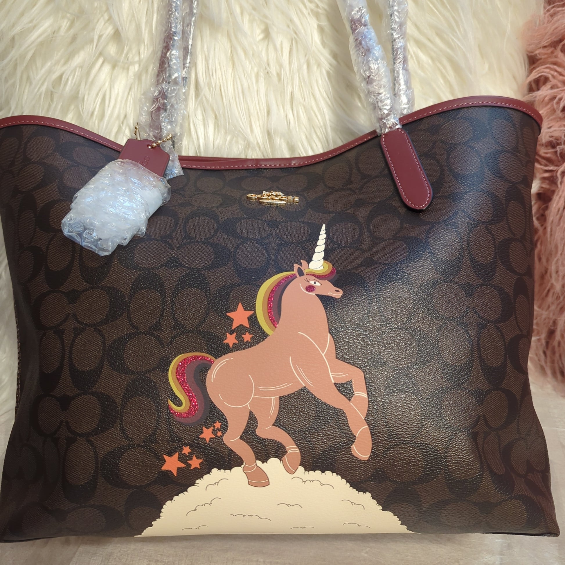 Coach Limited Edition Unicorn Reversible City Tote in Signature Brown/Black MultiExclusive Coach Unicorn Reversible Tote, signature canvas, and wine hue, glitter detailed. A stunning, versatile must-have.$599.00Boston304