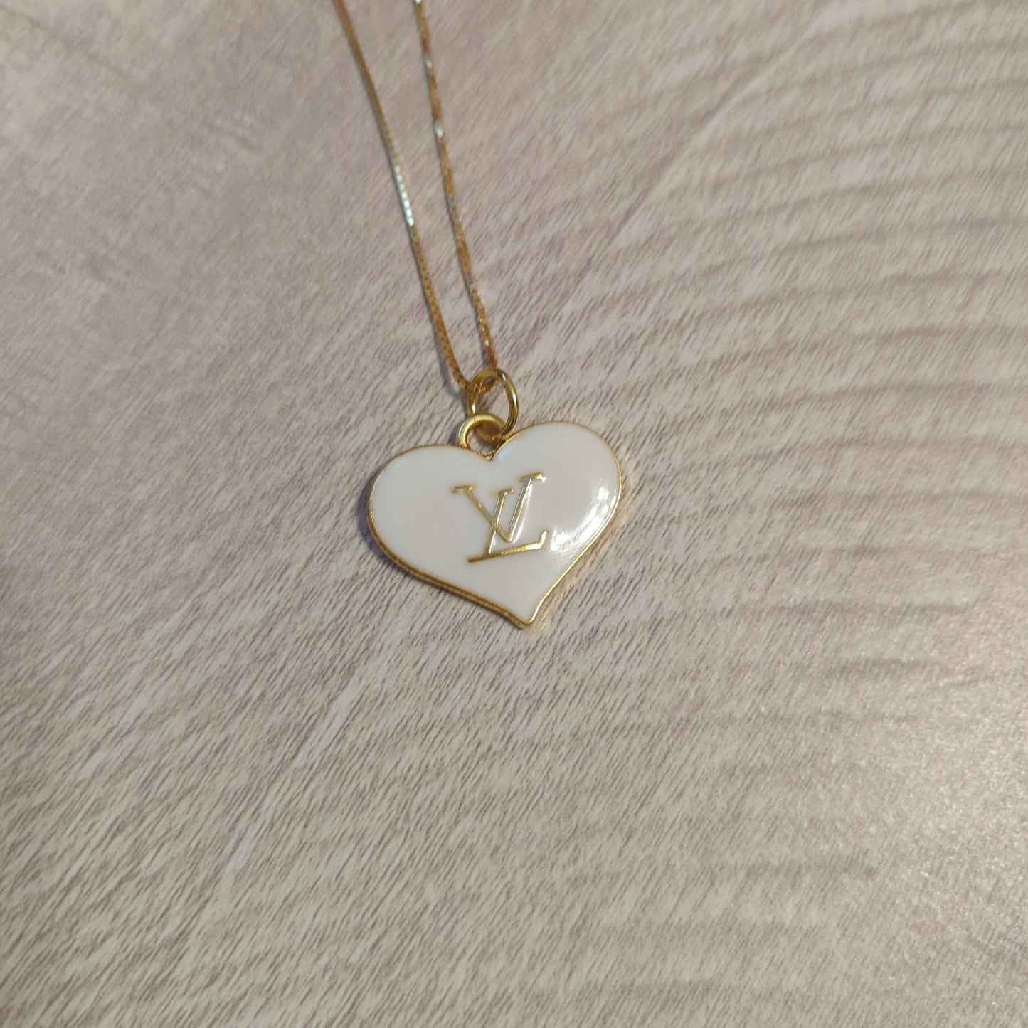 Louis Vuitton white heart charm upcycled to a necklace on an 18 inch box chain in 18k gold plate.Elevate your style with our upcycled Louis Vuitton white heart charm necklace on an 18" gold plated box chain. Perfect elegance.$179.00Boston304