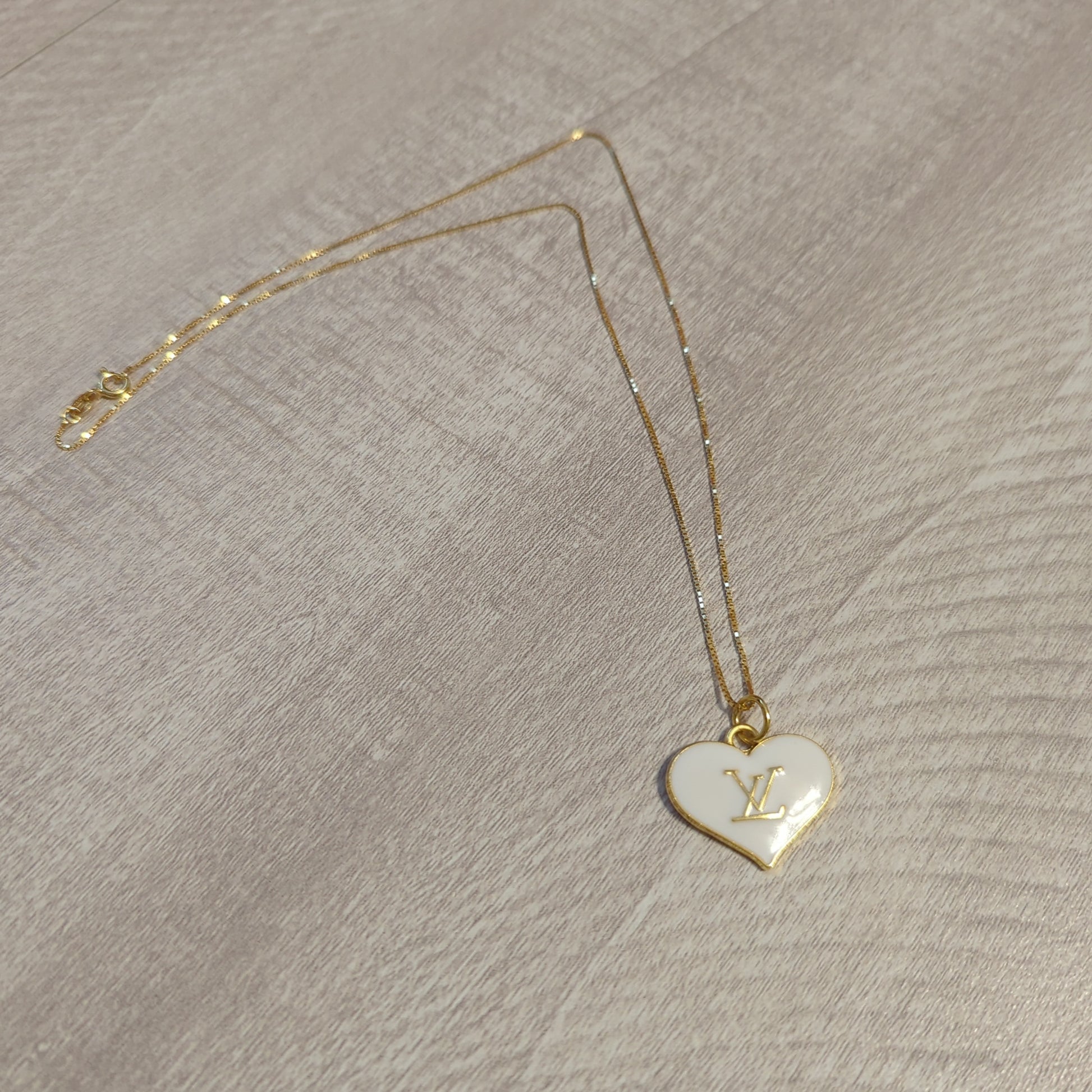 Louis Vuitton white heart charm upcycled to a necklace on an 18 inch box chain in 18k gold plate.Elevate your style with our upcycled Louis Vuitton white heart charm necklace on an 18" gold plated box chain. Perfect elegance.$179.00Boston304