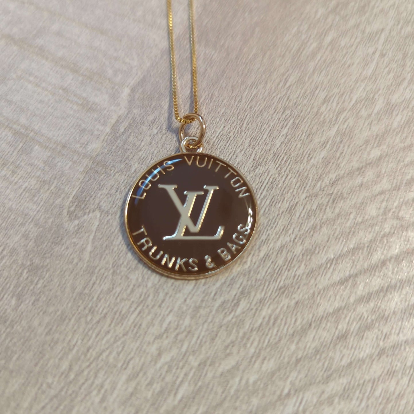 Louis Vuitton brown charm on 20 inch 18k plated necklaceBeautiful Louis Vuitton charm upcycled to a 20 inch 18k plated necklace in a gorgeous chocolate brown and gold. Perfect one inch charm.$199.00Boston304