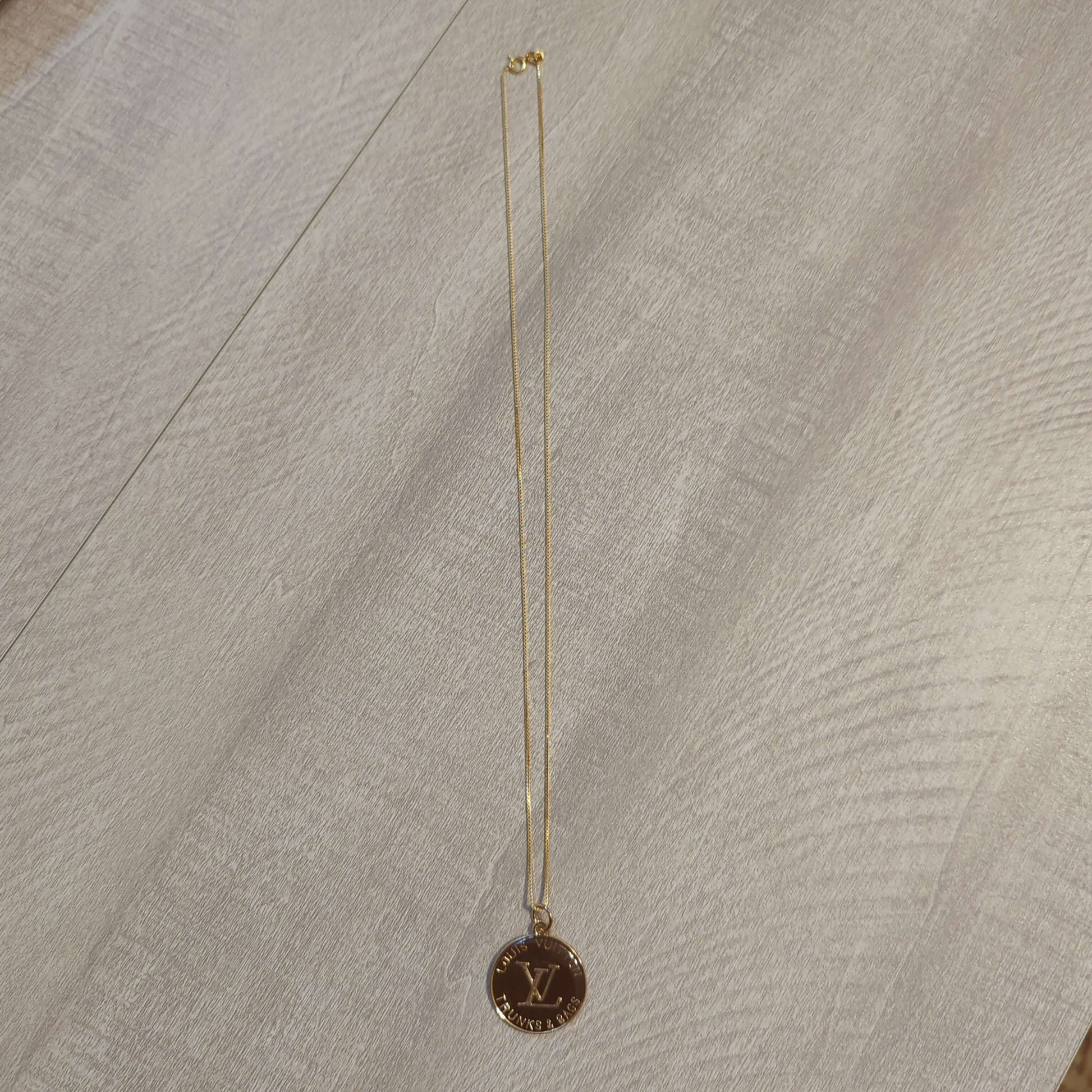 Louis Vuitton brown charm on 20 inch 18k plated necklaceBeautiful Louis Vuitton charm upcycled to a 20 inch 18k plated necklace in a gorgeous chocolate brown and gold. Perfect one inch charm.$199.00Boston304