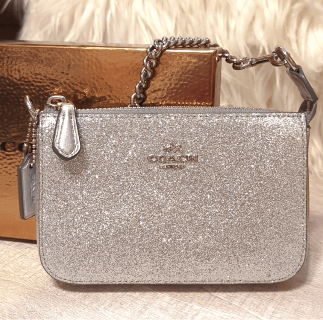 Coach Rare Glitter Chain Wristlet/Clutch BagOwn a vintage Coach wristlet with sparkling silver glitter. Versatile, pristine & boxed - perfect 6x4 luxury accessory. Shop rarity now!$169.00Boston304