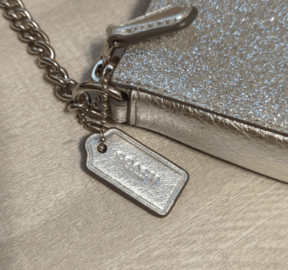 Coach Rare Glitter Chain Wristlet/Clutch BagOwn a vintage Coach wristlet with sparkling silver glitter. Versatile, pristine & boxed - perfect 6x4 luxury accessory. Shop rarity now!$169.00Boston304